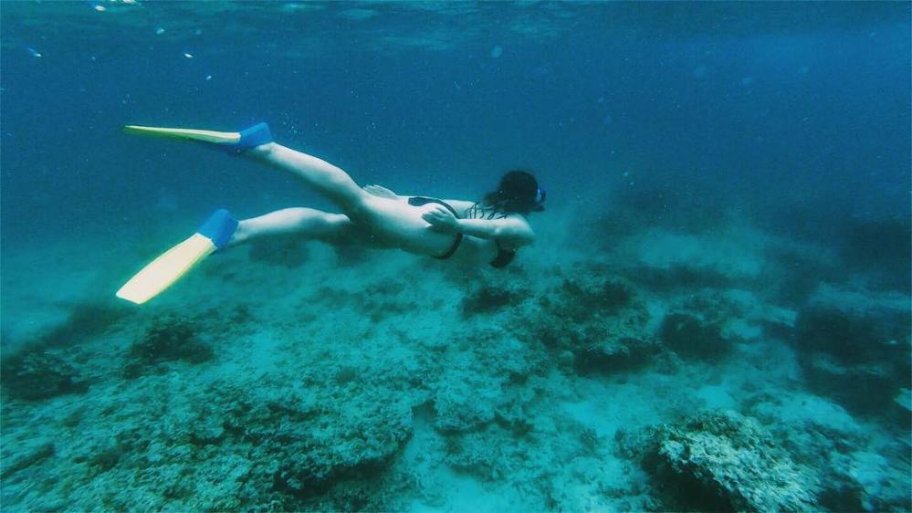Woman in flippers snorkels under the waters of Gili Trawangan
