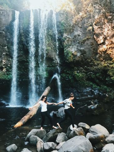 Two girls, hand-in-hand, exploring the rocks below Hopetoun Falls in Victoria, Australia